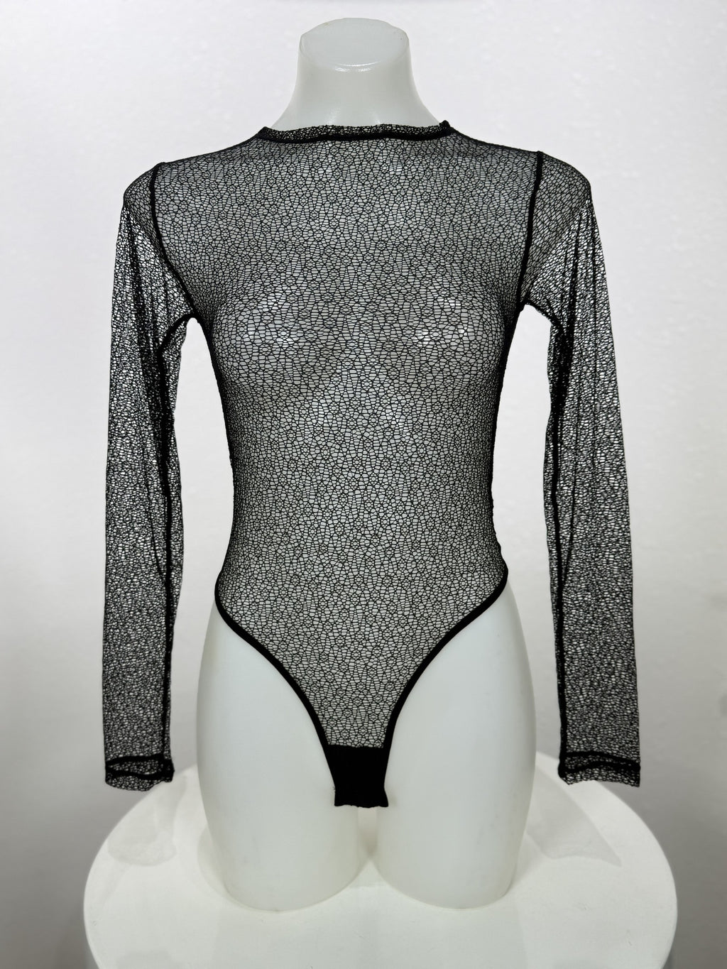 Front view of the Vervain black mesh bodysuit on a mannequin.