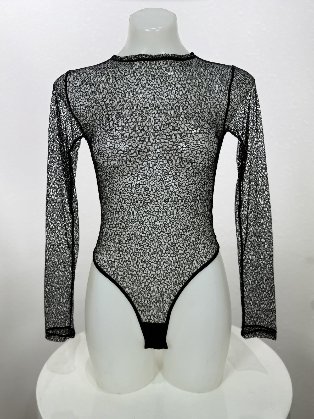 Front view of the Vervain black mesh bodysuit on a mannequin.
