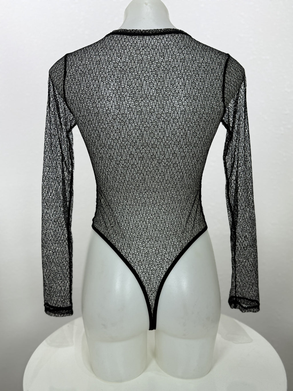 Back view of the Vervain black mesh bodysuit on a mannequin.
