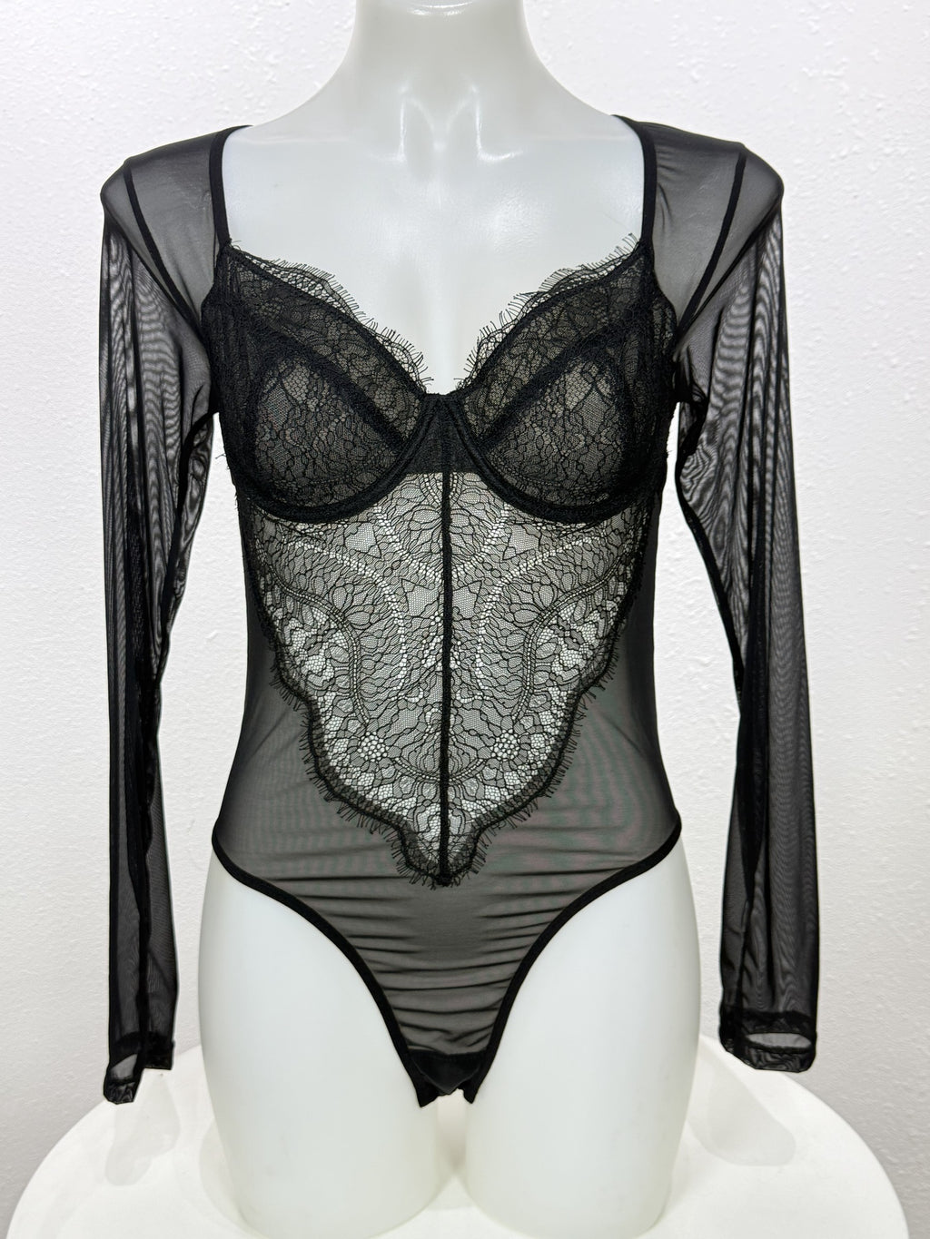 Front view of the Primrose black lace bodysuit on a mannequin.