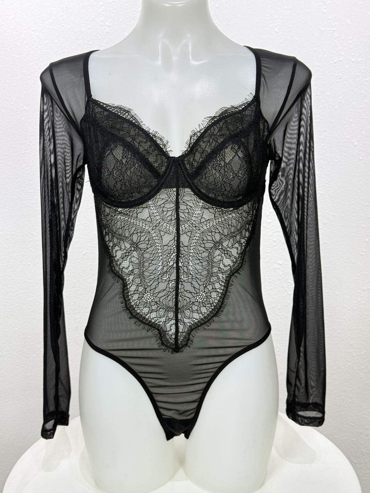 Front view of the Primrose black lace bodysuit on a mannequin.