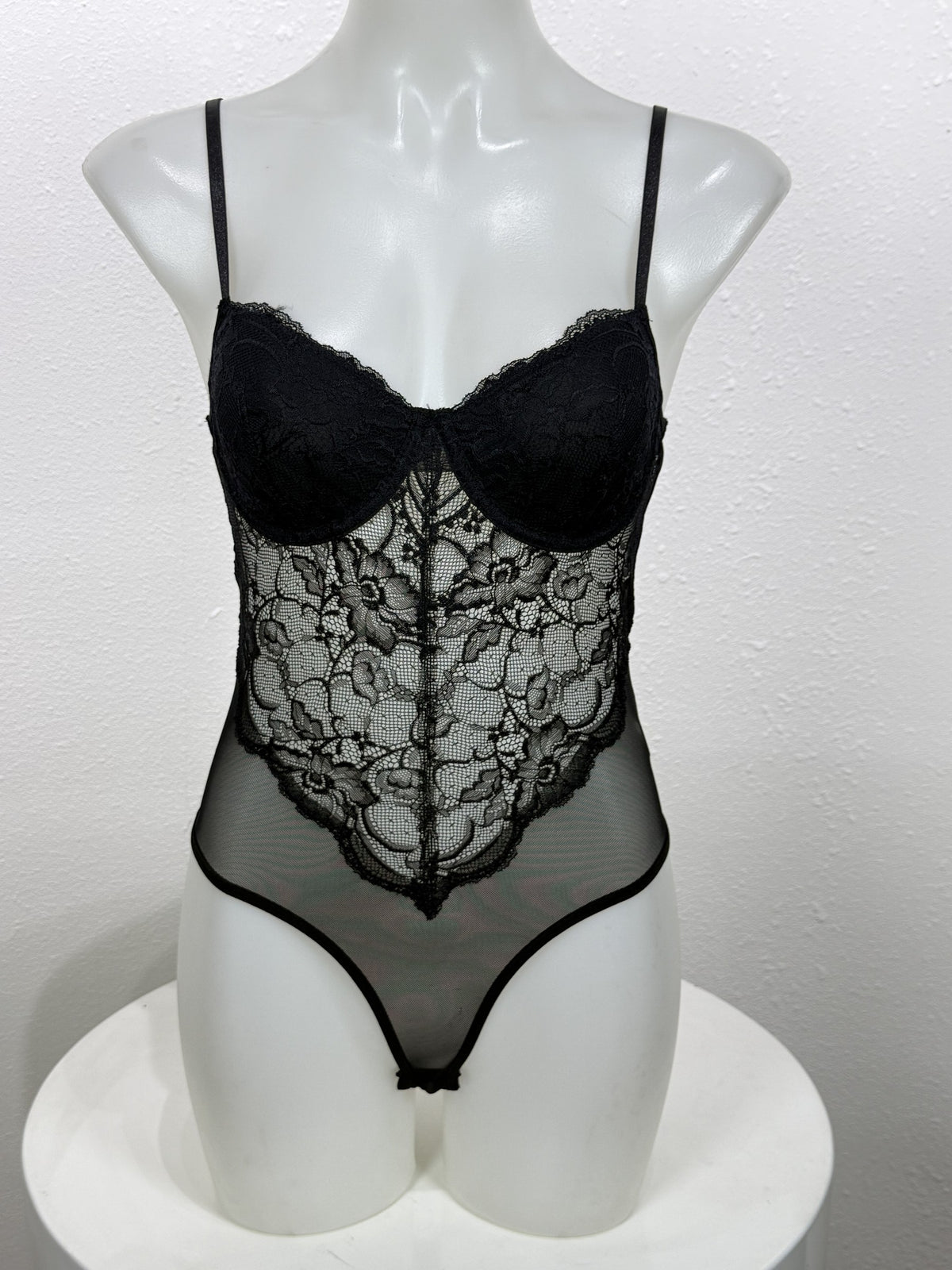 Front view of the Nightshade black lace bodysuit on a mannequin.